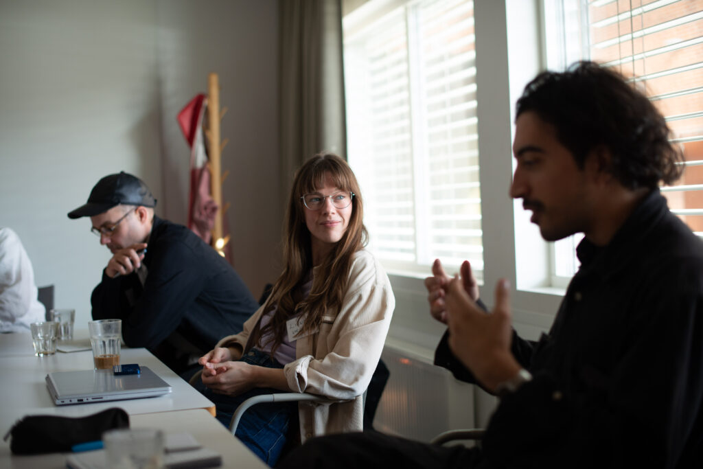 People sitting by a table, talking and listening.